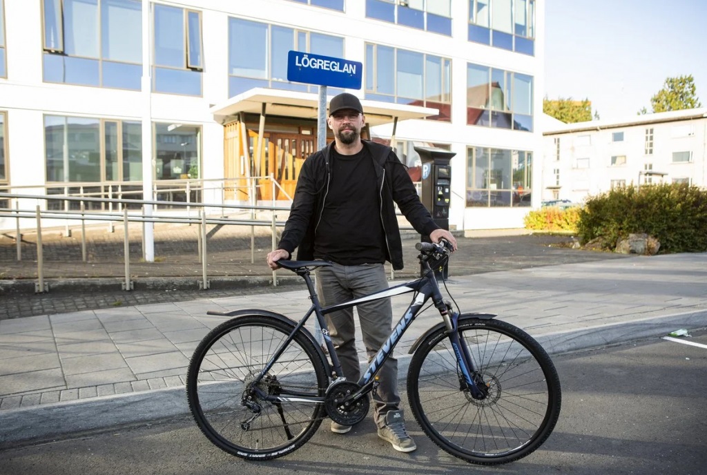 Man stands with a bike in front a building